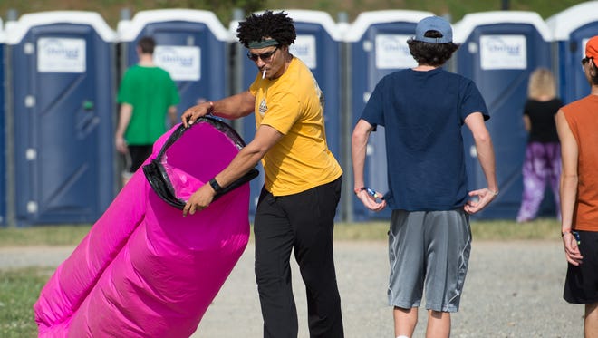 Alex Papa of Fairfax, Va., fills a Laybag with air in the camping area at the Firefly Music Festival in Dover.