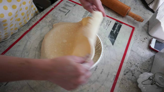 Amy Watson Bish lays freshly made pie crust over a pie pan in her kitchen while preparing for the upcoming pie making contest at the Delaware State Fair.