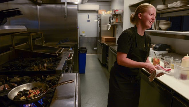 Julia Robinson, Chef de cuisine at The Blue Hen, prepares a mussel dish in the kitchen on Monday, August 7, 2017.