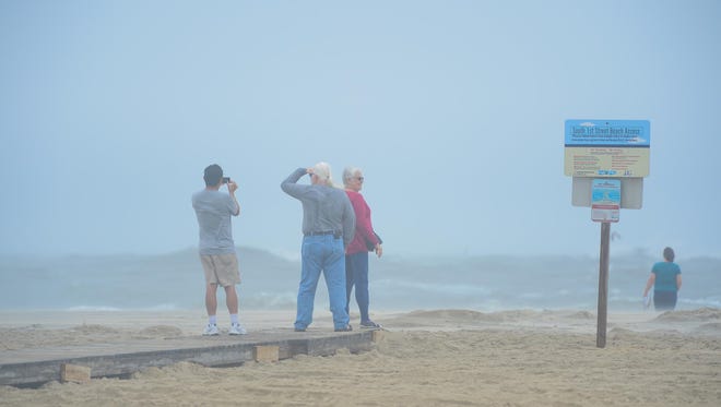 People take photos of the rough surf in Ocean City, Md. as Hurricane Maria is off the coast in the Atlantic Ocean on Wednesday, Sept. 27, 2017.