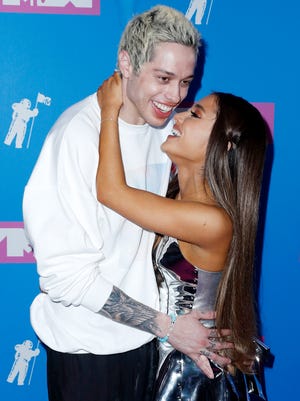Engaged couple Ariana Grande and Pete Davidson canoodle on the carpet at the VMAs.