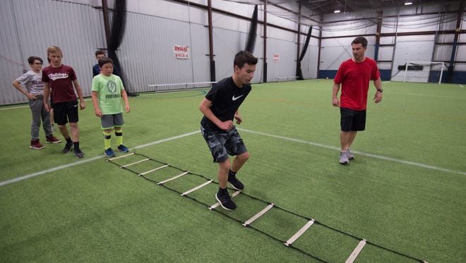 Jeff Simpson, right, owner and head strength coach with Sports Specific Training, works with a group of athletes at Slim's Sport Complex in Middletown.