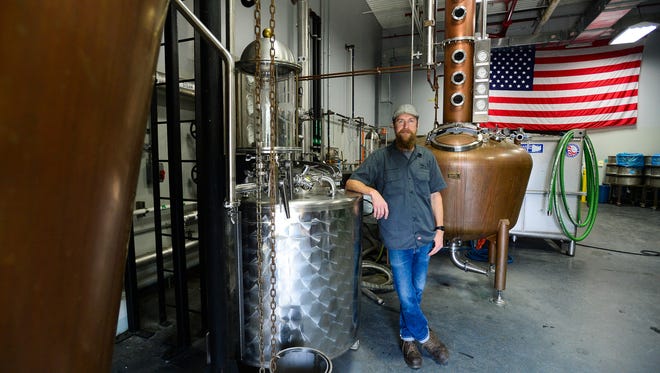 Dogfish Head's lead distiller Graham Hamblett, stands among the brass stills at the Dogfish Head Distillery located in Milton, Del. on Friday, July 14, 2017.