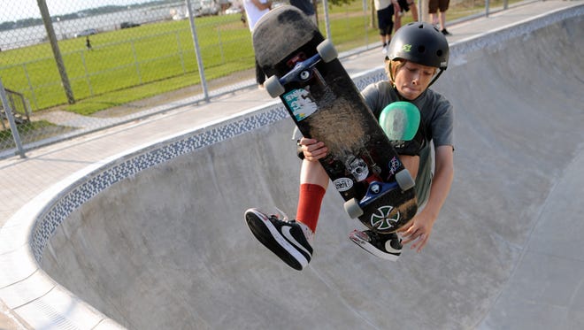 A young skateboarder attempts a flip trick at the Ocean Bowl in Ocean City. The well-worn knee pads were needed.