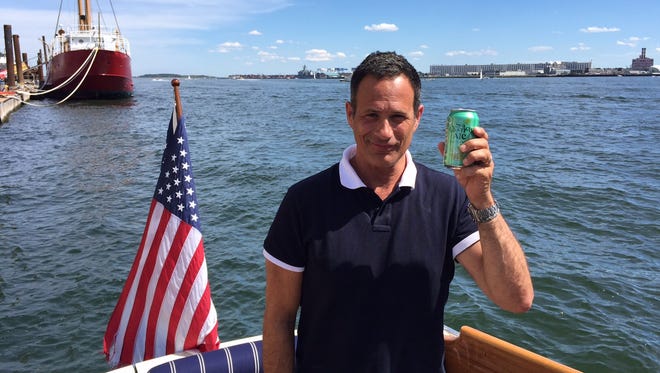 Sam Calagione, co-founder of Dogfish Head Craft Brewery, sailing in Boston Harbor, with a can of SeaQuench Ale.
