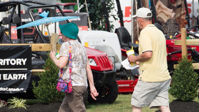 A fair goers uses a umbrella to beat the heat at the 98th annual Delaware State Fair in Harrington.