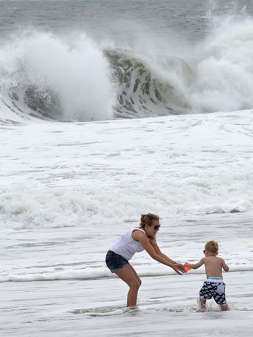 A woman and child play in the surf at Rehoboth Beach on Monday.
