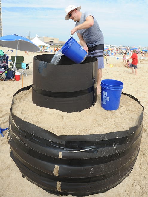 Adam Basalyga from Scott Township, PA. dumps water to harden the sand as he starts to build his castle as The 38th Annual Rehoboth Beach-Dewey Beach Chamber of Commerce Sandcastle Contest was held on Saturday, Sept. 10, 2016 at a new location on the south end of the beach near Funland under hot weather conditions.  Participants worked to create different castles and sculptures in the sand for judging in the late afternoon at which time trophy's ail be given out.