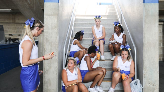 Cheerleads for the blue squad have lunch during the Blue-Gold football media day Sunday at Delaware Stadium in Newark.