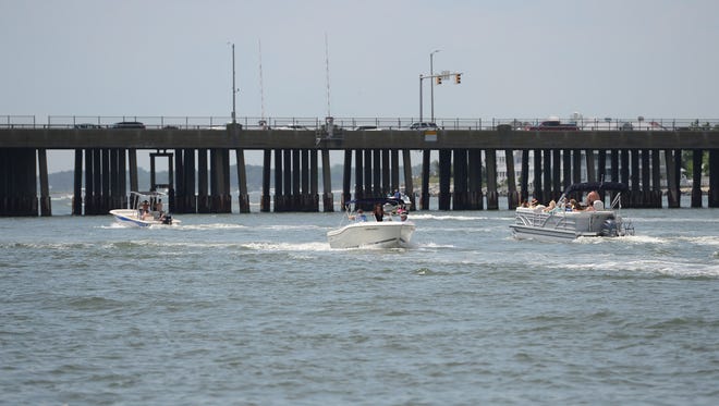 Boats travel from the bay to the ocean underneath the Route 50 bridge in Ocean City, Md., during the holiday week on July 3, 2017.