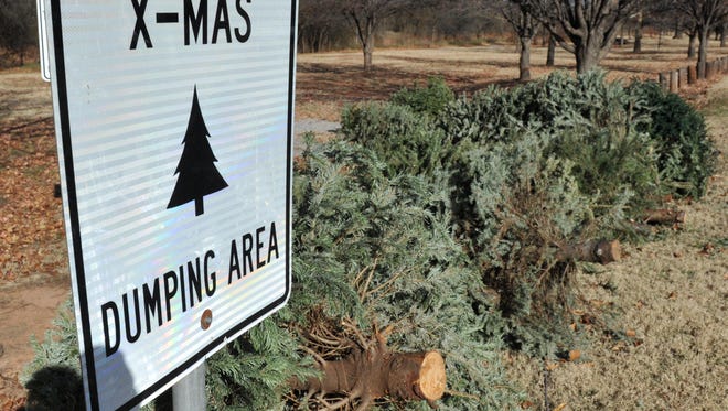 A sign directs people to where they can safely dispose of their Christmas trees.