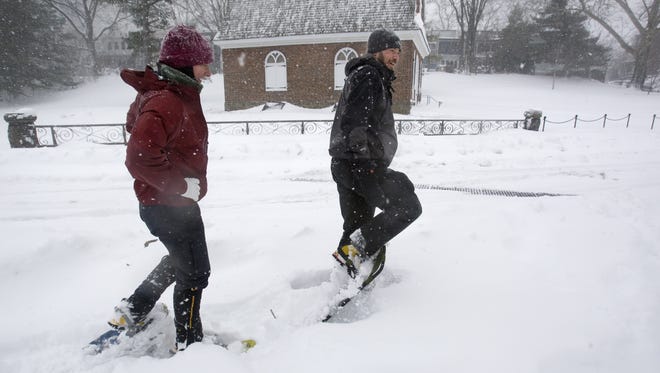 Jenny Krumrie and her boyfriend, John Lehmann, snowshoe past the First Presbyterian Church on S. Park Drive along the Brandywine River as snow continues to fall in Wilmington, Saturday afternoon, Feb. 6, 2010.