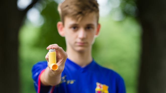 Meredith Hurst's son, Daniel, 16, holds his asthma inhaler at Canby Park West on Monday. Those vulnerable to the chemical ozone have been dealing with poor air in Delaware for years.