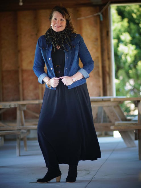 Virginia Griffith wears a black maxi dress with gold buckle trim from Marshalls; jean jacket from QVC; black and gold infinity scarf from Dress Barn; and black booties with gold zipper from QVC.