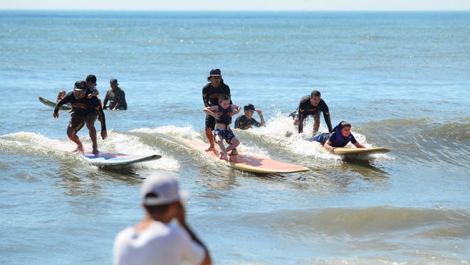 Volunteer surfers help out with the Surfers healing tour to help people living with autism by exposing them to a surfing experience in Ocean City on August 17, 2016.