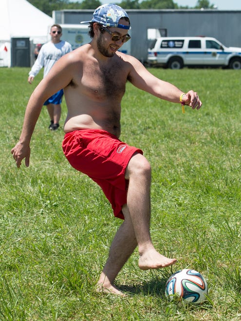 Kyle Laires of Ludlow, Mass., plays soccer on a field that the Firefly Music Festival set up in the north camping area, a request that festival goers ask for this year.