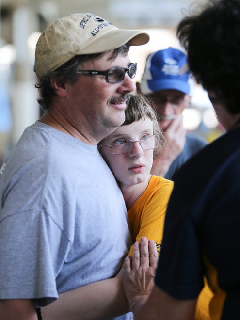 Carrie Hallett, 15 hugs her dad, Ronald Hallett, during media day for the Blue-Gold football All-Star game Sunday at Delaware Stadium in Newark.
