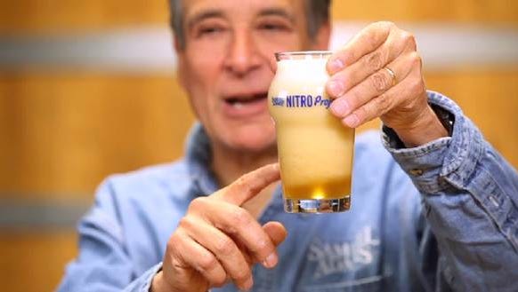 Boston Beer Co. Founder and Chairman Jim Koch holding a just-poured Samuel Adams Nitro White Ale.
