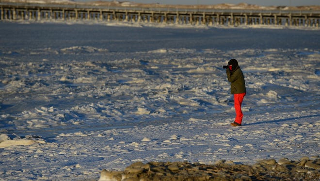 A man photographs a frozen Delaware Bay on Friday, Jan. 5, 2018.