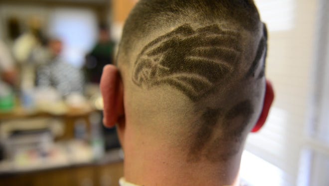 Paul Cusimano, Millville Barbershop Co-Owner, gets a Super Bowl LII themed custom hair cut by Barber Victor Hernandez on Thursday, Jan. 25, 2018.