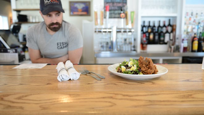 Matt's Fish Camp's bartender Chris Needham listens about the featured menu items that day: fried chicken livers, served with mixed greens, hard-boiled egg, kimchi aoli and buttermilk blue cheese dressing. on Tuesday, Feb. 13, 2018 at Matt's Fish Camp in Lewes, Del.