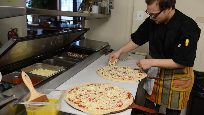 Albertino's Pizza Chef Hunter Prenner, prepares hand made wood fired pizza's on Wednesday, Feb. 28, 2018.