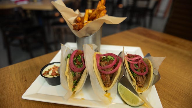 Bayside Cantina's Barbacoa taco's- slow roasted beef, pickled red onion, cilantro, roasted tomato and serrano sauce. Served with chili-dusted fries & queso. Tuesday, May 1, 2018.