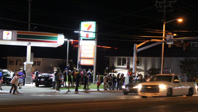 A crowd gathered at the 7-Eleven near 56th Street to watch modified cars drive up and down Coastal Highway on Friday, Sept. 29.