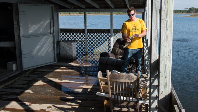 Brady Stevens unhooks a fish at his Calvary Road fishing cabin on Sunday, Nov. 5, 2017. The King Tide caused partial flooding in the cabin.