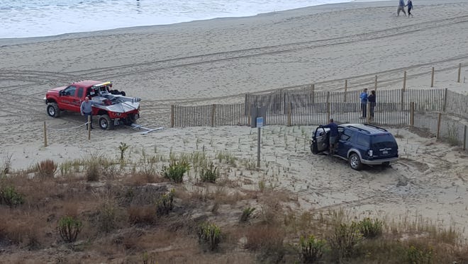 A tow truck pulls an SUV off the 99th Street dune after the vehicle crashed there, Ocean City police say.