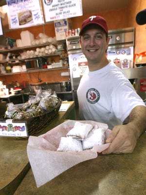 In this 2008 photo, Don Applebaum offers up beignets at Cajun’s Kate, a New Orleans-style eatery in Booths Corner Farmers Market in Boothwyn, Pa.