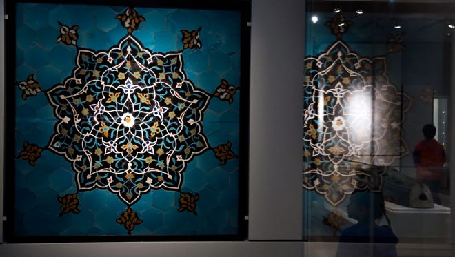 In this April 26, 2018 photo, a wall panel of glazed terra-cotta, from a Sufi monastery in Iran, circa 1400 to 1520 BCE, hangs in the Middle East Galleries at the Penn Museum in Philadelphia. The University of Pennsylvania Museum of Archaeology and Anthropology is opening the galleries to showcase hundreds of previously undisplayed items, and is making the artifacts more relatable by adding guides native to those parts of the world.