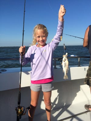 Seven-year-old Madison Wyant proudly shows off her croaker.