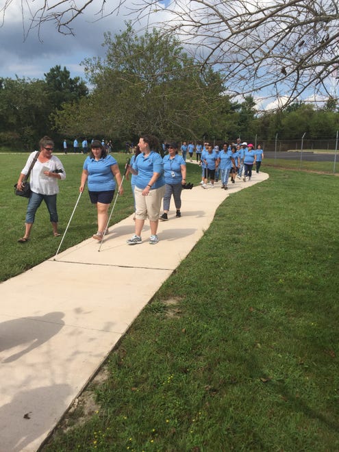Participants walk the new community walking path, courtesy of Blind Industries and Services of Maryland.