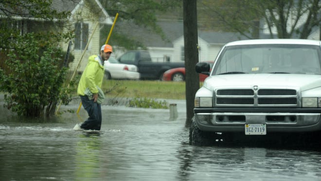 An unidentified man walks through flood waters to a truck waiting for him in Sanford, Va. on Tuesday, Oct. 30, 2012. Nearby Saxis Island was evacuated by the Virginia National Guard early Tuesday morning because of flooding by Hurricane Sandy.