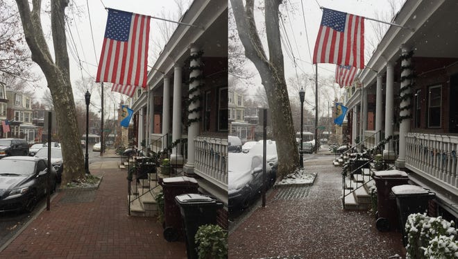 Wilmington's first snow of the year arrived Saturday morning. These photos were taken about three hours apart. Pictured here are flags hung outside homes in Wilmington.