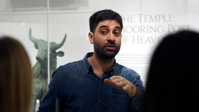 In this April 26, 2018 photo, Abdulhadi Al-Karfawi guides visitors though the Middle East gallery in the Penn Museum, in Philadelphia. The University of Pennsylvania Museum of Archaeology and Anthropology is in the midst of dramatic renovations, opening new galleries to showcase previously undisplayed items, telling the stories of those artifacts in more relatable ways and adding guides native to the parts of the world being showcased.