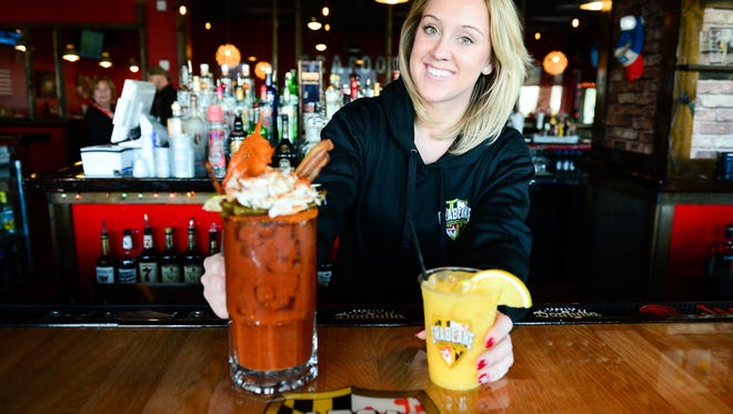 Crab Cake factory bartender Jackie Jenkins with their famous bloody mary and orange crush on Friday, Dec. 23, 2016.