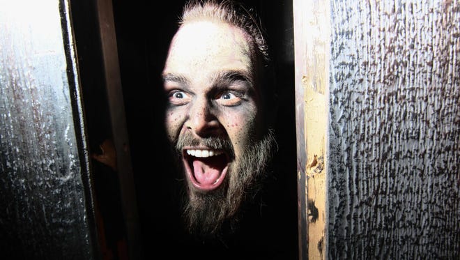 A actor scares guest from hidden location in haunted house attraction at Frightland in Middletown.
