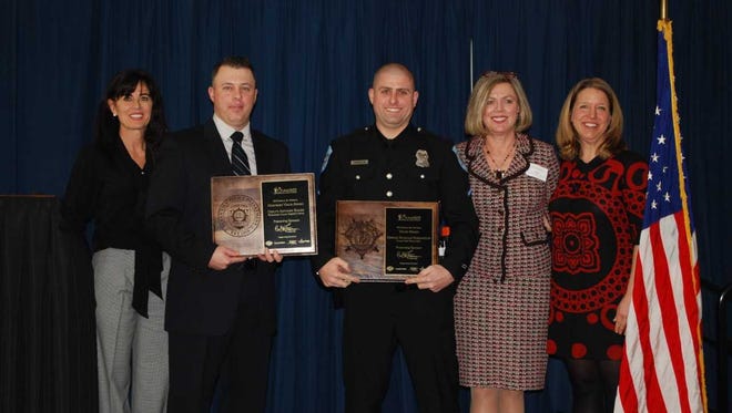 Officer First Class Nicholas Harrington (center right) of the Ocean View Police Department and Deputy First Class Anthony Rhode of Worcester County Sheriff's Office (center left) receive an award for valor from the Overall Bethany-Fenwick Area Chamber of Commerce and Carl M. Freeman Companies.
