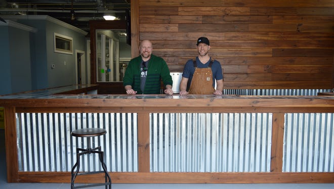 Harry Metcalfe and Patrick Staggs of Revelation Brewing Company smile behind their microbrewery bar, located in West Rehoboth, on March 23, 2016.