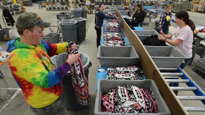 Mark Sigmon, left, retail line processor, and Roni Lay, line leader, sort merchandise at the new South Moon Under distribution facility in Salisbury.