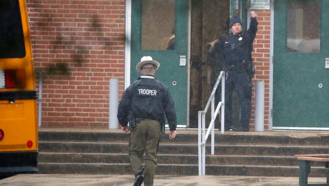 A policeman gives a thumbs-up after moving students into a different area of Great Mills High School, the scene of a shooting, March 20, 2018 in Great Mills, Md. .