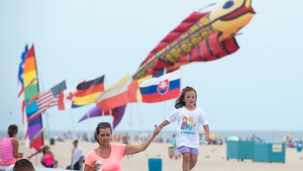 Kites soar along a crowded Ocean City Boardwalk.