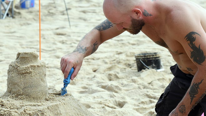 Jeff Fake from Lebanon, PA, works in the heat to create a sand castle.