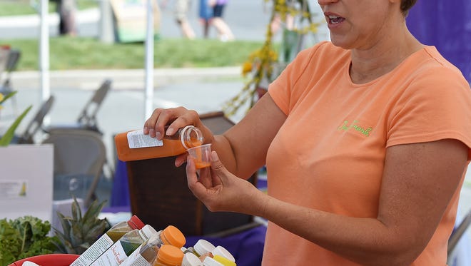 Melissa Harrison from "Juice Fresh" in Rehoboth Beach pours a sample.