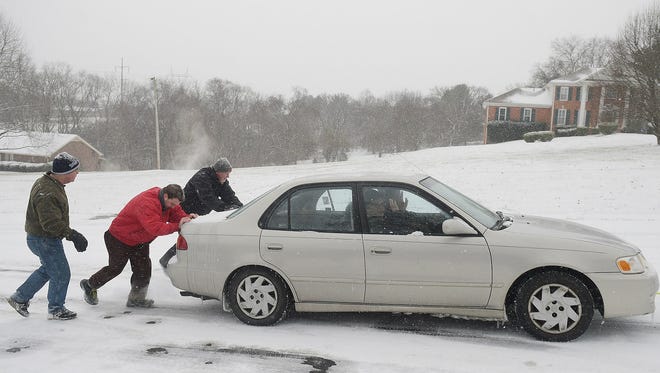 John Bass, Kyle Piccirilli and Jud Haynie  push car up an icy hill in Brentwood, Tn.