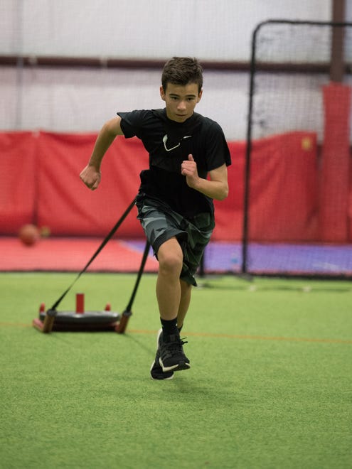 Jacob Simpson (13) runs with a weighed sled during a training session with Sports Specific Training at Slim's Sport Complex in Middletown.
