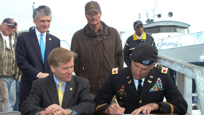 From left, Congressman Scott Rigell, Gov. Bob McDonnell and Tangier's mayor, James "Ooker" Eskridge, look on as Col. Paul Olsen, Norfolk District commander, signs a proclamation Nov. 20, 2012. The governor and the U.S. Army Corps of Engineers recently announced plans to build a long-awaited jetty to protect the island's endangered harbor. With the Corps' agreement several weeks ago to commit federal funds, a cost-sharing agreement with the Commonwealth was signed and the project approved for study, design and construction.