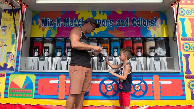 Robert Lorntzen and his son Blake (5) of Thousand Oaks, Calif., get a cold drink at the Slush Factory at the 98th annual Delaware State Fair in Harrington.